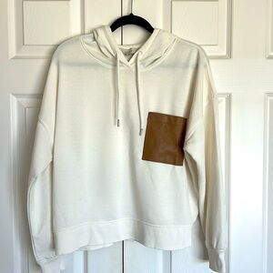 Cream colored lightweight hoodie with a faux brown oversized pocket